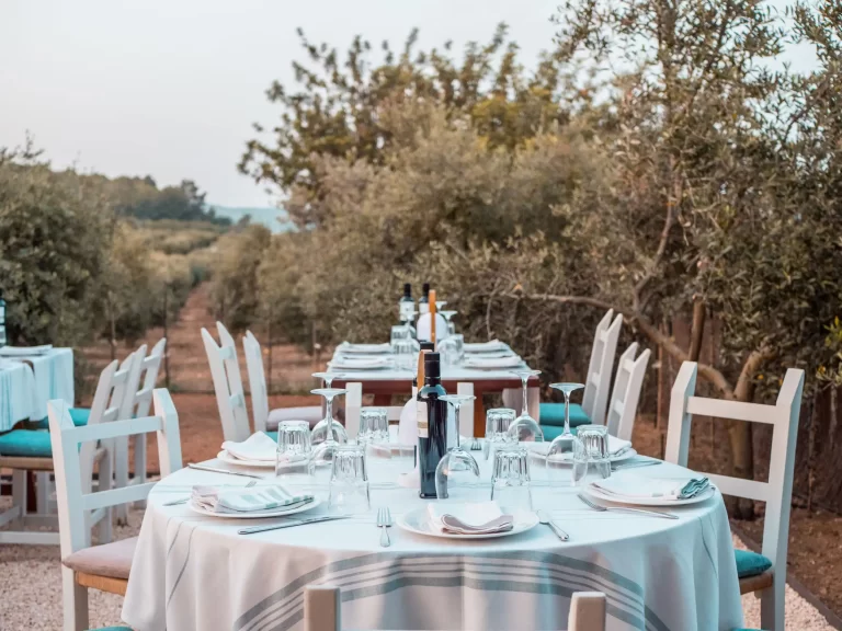 Detail of restaurant tables among olive trees